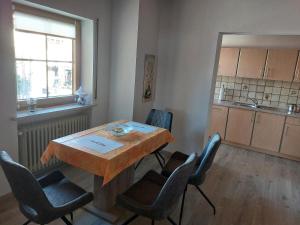 een kamer met een tafel en stoelen en een keuken bij Ferienwohnung Elisabeth Biebl in Neuschönau