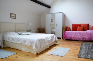 1 dormitorio con 1 cama y 1 sofá en La Quinta, belle maison en pierres avec jardins, en Asnelles