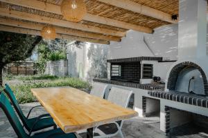 patio con mesa de madera y horno al aire libre en Serotonin en Zakynthos