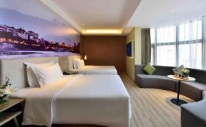 a hotel room with two beds and a couch at Atour S Hotel Chunxi Road Chengdu in Chengdu