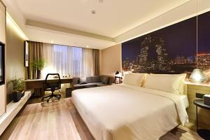 een hotelkamer met een groot bed en een bureau bij Atour Hotel Financial Street Beijing in Beijing