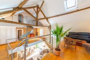 una sala de estar de planta abierta con una escalera de caracol en Domaine de Jade - Maison de Maître pour 15, en Châtillon-la-Borde