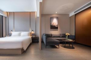 Habitación de hotel con cama y sofá en Atour Hotel Shenzhen Qianhai Baoan Center, en Bao'an