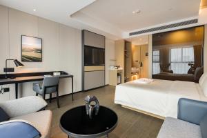 Atour Hotel Chongqing Qibo Center في تشونغتشينغ: غرفة في الفندق مع سرير ومكتب