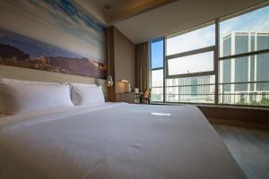 a large white bed in a room with a large window at Atour Hotel Jinan High-tech Wanda Plaza Tiancheng Road in Jinan