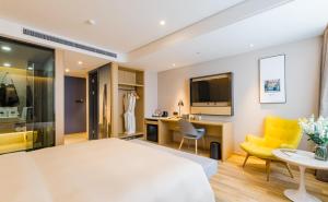 sypialnia z łóżkiem, biurkiem i żółtym krzesłem w obiekcie Atour S Hotel Lujiazui Oriental Pearl Shanghai w Szanghaju