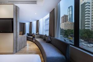 Atour Hotel Changsha IFC Center في تشانغشا: غرفة في الفندق مع أريكة ونافذة كبيرة