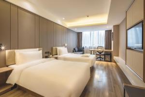 Habitación de hotel con 2 camas y TV en Atour Hotel Qingdao Olympic Sailing Center May Fourth Square, en Qingdao