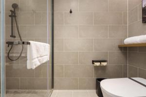 a bathroom with a shower and a toilet at Dalian Airport Yingke Road Atour Hotel in Dalian