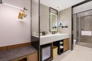 La salle de bains est pourvue d'un lavabo et d'une douche. dans l'établissement Atour Hotel Dalian Airport, à Dalian