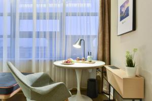 順義にあるAtour Hotel Beijing Linkong New International Exhibition Centerのテーブルと椅子、窓が備わる客室です。