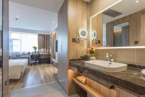 a bathroom with a sink and a bed and a mirror at Atour Hotel Changsha IFC Center in Changsha