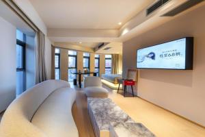 sala de estar con sofás y TV de pantalla plana. en Atour S Hotel Beijing Guomao CBD - FunsCenter, en Beijing