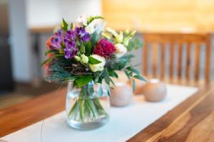 eine Glasvase voller Blumen auf dem Tisch in der Unterkunft Hochwertiges Apartment / 120m² / Dachterrasse / Parking in Dresden