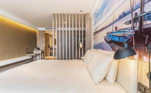 深セン市にあるAtour Hotel Shenzhen Nanshan Science and Technology Park Keyuan Roadのベッドルーム1室(ベッド1台付)が備わります。壁には絵画が飾られています。