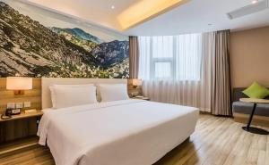 a hotel room with a large white bed and a window at Atour Hotel Xi'an Bell Tower North Street Station in Xi'an