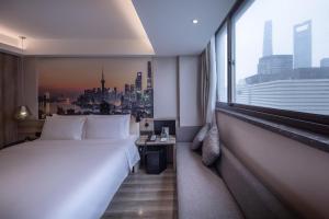 um quarto de hotel com uma cama grande e uma janela em Atour Hotel Shanghai Lujiazui Babaihan em Xangai
