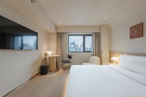 um quarto de hotel com uma cama e uma janela em Atour S Hotel Beijing Guomao CBD - FunsCenter em Pequim