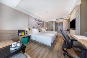 a hotel room with a large bed and a desk at Atour Hotel Three Lanes and Seven Alleys Fuzhou in Fuzhou