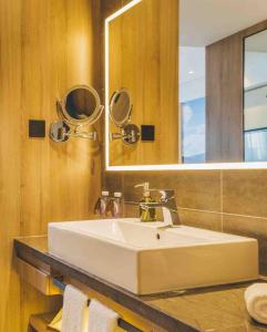 a bathroom with a white sink and a mirror at Ningbo Tianyi Square Atour Hotel in Ningbo