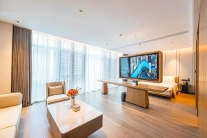 a living room with a large television and a couch at Atour Hotel Shenzhen Baoan Vanke Star City in Bao'an