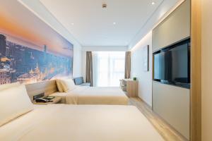 上海市にあるAtour Hotel Shanghai Hongqiao Korea Streetのベッド2台、薄型テレビが備わるホテルルームです。