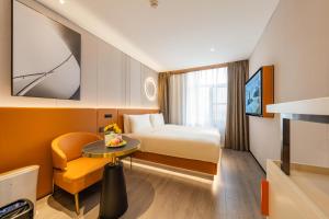 um quarto de hotel com uma cama e uma mesa e uma televisão em Atour Hotel Beijing Tiananmen Wangfujing Pedestrian em Pequim