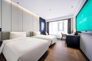 a hotel room with two beds and a tv at Atour Hotel Dalian Development Zone in Dalian