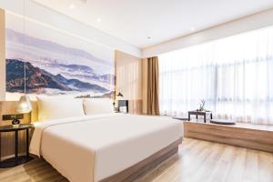 a bedroom with a large white bed and a large window at Atour Hotel, Haizhu Jiangtai Road Subway Station, Guangzhou-Free shuttle bus service at the Canton Fair in Guangzhou