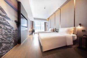 a bedroom with a large white bed in a room at Atour Hotel Shenzhen Shajing International Convention and Exhibition Center in Bao'an