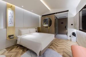 a bedroom with a white bed and a tv at Atour S Hotel Beijing Zhongguancun Beiwai in Beijing