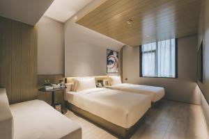 a hotel room with two beds and a window at Atour Light Hotel Shanghai East Nanjing Road 130 in Shanghai