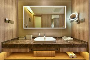 ein Bad mit einem Waschbecken und einem Spiegel in der Unterkunft Atour Hotel Beijing Chaoyang Park in Peking