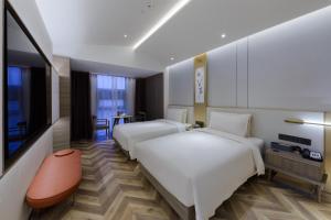 a hotel room with two beds and a flat screen tv at Atour S Hotel Beijing Zhongguancun Beiwai in Beijing