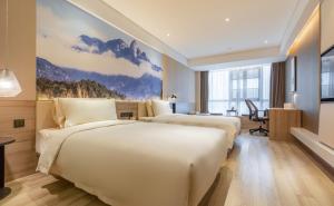 um quarto de hotel com duas camas e uma secretária em Atour Hotel Wuhan Tianhe Airport Tenglong Avenue Subway Station em Wuhan