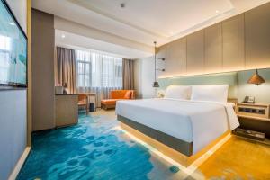 a hotel room with a large bed and a desk at Atour X Hotel Zhujiang New Town Tianhe Park Station Guangzhou close to Canton Fair -Free shuttle bus to Canton Fair in Guangzhou +55 photos