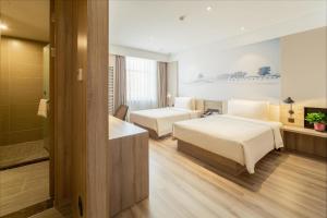 ハルビン市にあるAtour Hotel Harbin Convention and Exhibition Center Nongkenのベッド2台とバスルームが備わるホテルルームです。