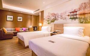 済南市にあるAtour Hotel Jinan High-tech Wanda Plaza Tiancheng Roadのベッド2台とソファが備わるホテルルームです。