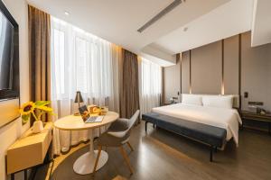 順義にあるAtour Hotel Beijing Linkong New International Exhibition Centerのベッドとデスクが備わるホテルルームです。
