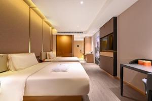 Habitación de hotel con 2 camas y escritorio en Atour Hotel Changchun Automobile Development Zone en Changchún