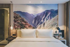 Schlafzimmer mit einem Bett mit Wandgemälde in der Unterkunft Atour Hotel Chongqiang Jiangbei Airport in Chongqing