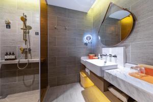 uma casa de banho com um lavatório e um espelho em Atour Hotel Chongqing Jiangbei International Airport Huixing Light Rail Station em Chongqing