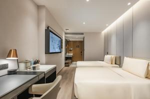 a hotel room with two beds and a flat screen tv at Atour Hotel Chengdu Taikoo Li Chunxi Road Pedestrian in Chengdu