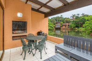a patio with a table and chairs and a view of a lake at San Lameer Villa 2026 - One bedroom Classic - 2 pax - San Lameer Rental Agency in Southbroom