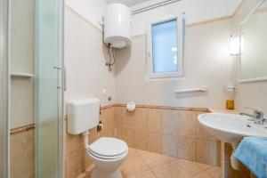 ein Badezimmer mit Toilette und Waschbecken in der Unterkunft Garden apartment in Baška