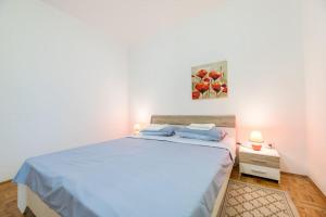 ein Schlafzimmer mit einem großen Bett mit einer blauen Decke in der Unterkunft Garden apartment in Baška