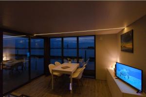 a living room with a dining table and a television at Hausboot Fjord Aries mit Dachterrasse in Schleswig in Schleswig