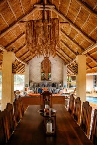 a dining room with a long table and a chandelier at Amanzi Lodge in Harare