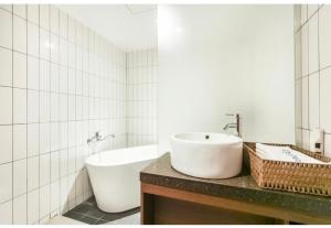 a white bathroom with a sink and a tub at Hotel Egg in Busan