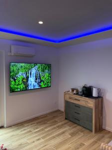 Habitación con TV en la pared y escritorio. en Luxury spa vallon en Vallon-Pont-dʼArc